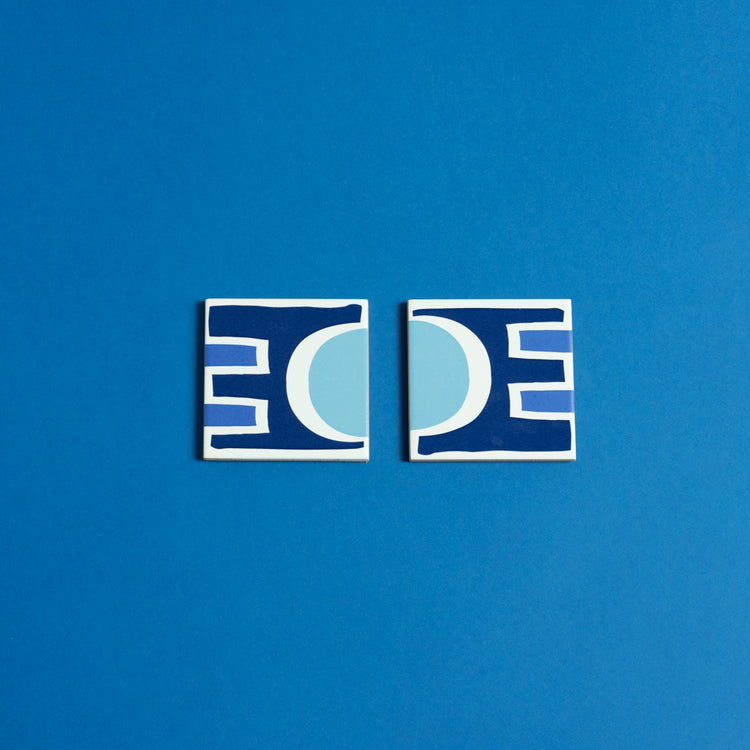 Porcelain coasters with abstract geometric shapes in a bold color palette.