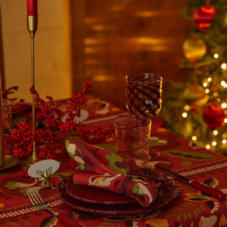 Festive set table with red tablecloth, napkins and plates