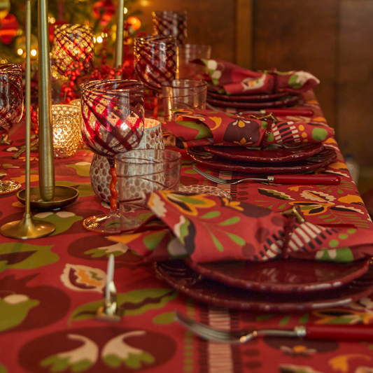 Festive set table with red tablecloth, napkins and plates